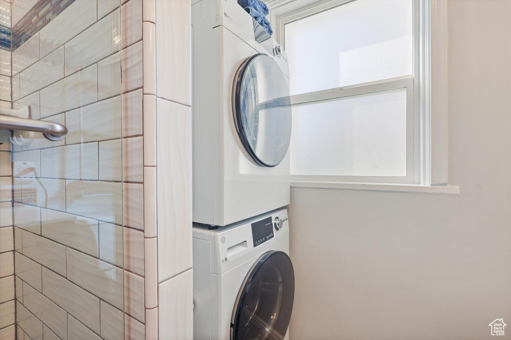 Laundry room featuring stacked washer / drying machine and laundry area