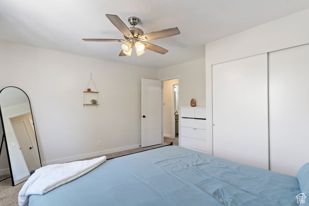 Bedroom featuring a closet, baseboards, carpet flooring, and ceiling fan