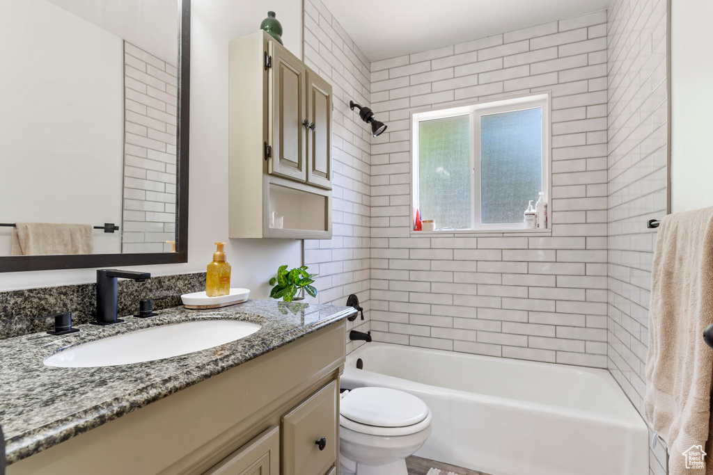 Bathroom with washtub / shower combination, vanity, and toilet