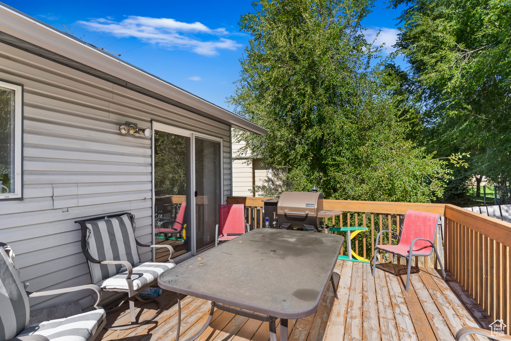 Wooden terrace featuring a grill