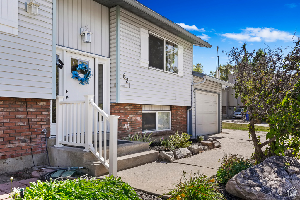 Exterior space with brick siding, an attached garage, and concrete driveway