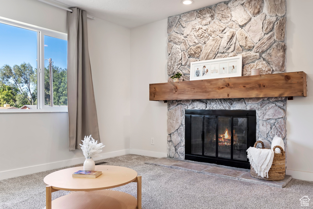 Living room with a fireplace, carpet flooring, and baseboards