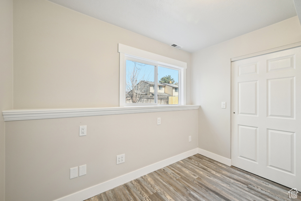Unfurnished bedroom with visible vents, baseboards, and wood finished floors