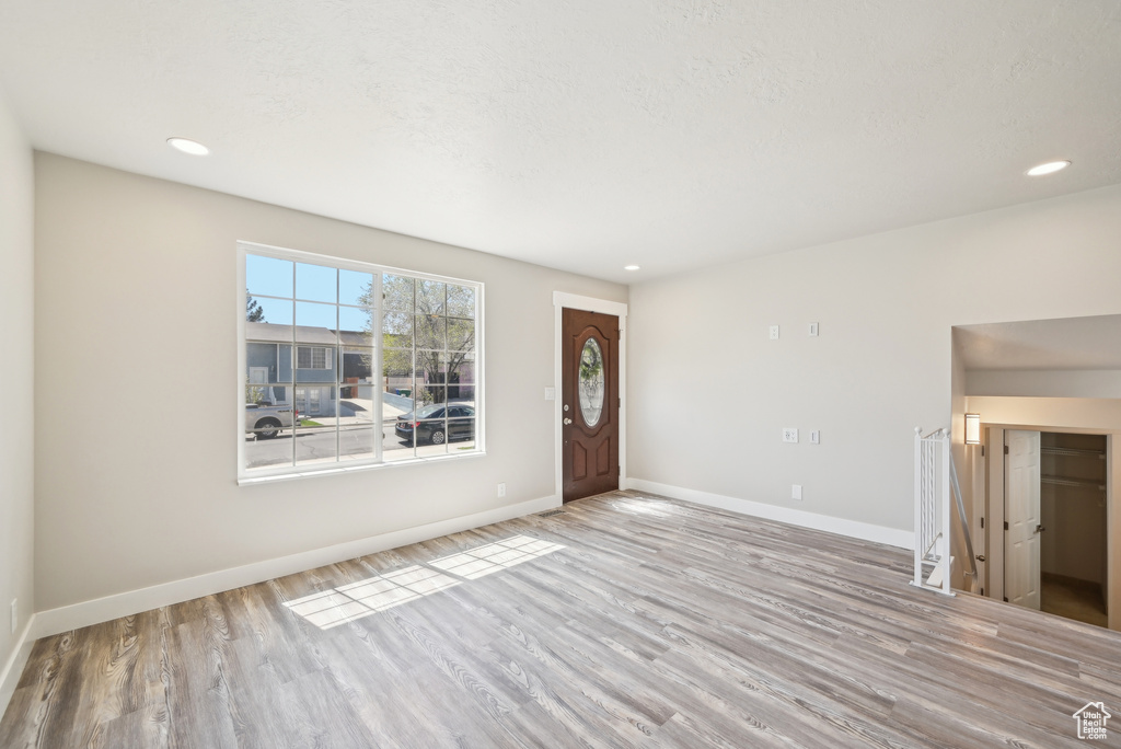 Foyer entrance with wood finished floors, baseboards, and recessed lighting