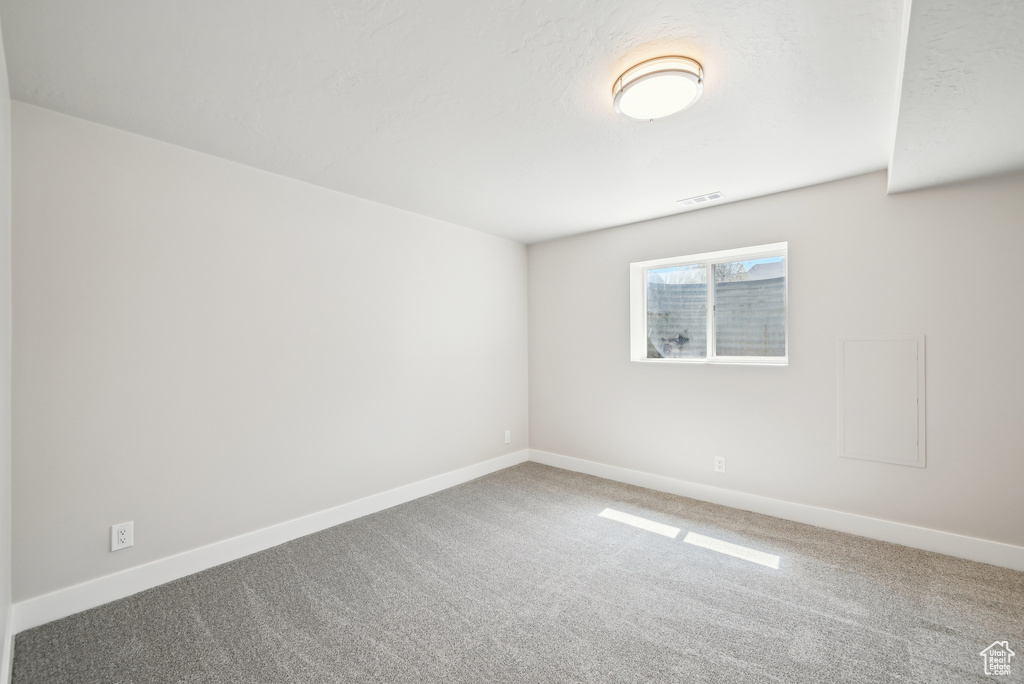 Carpeted spare room with baseboards