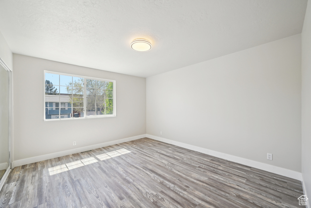 Spare room with baseboards and wood finished floors