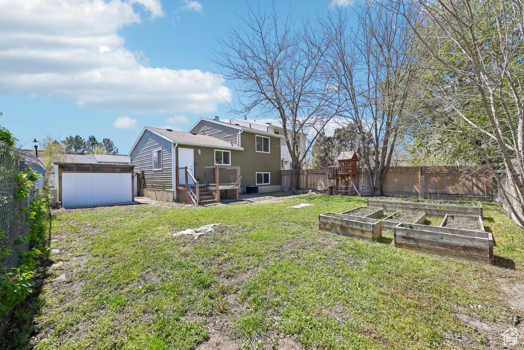 View of yard with an outbuilding, a garden, and a fenced backyard