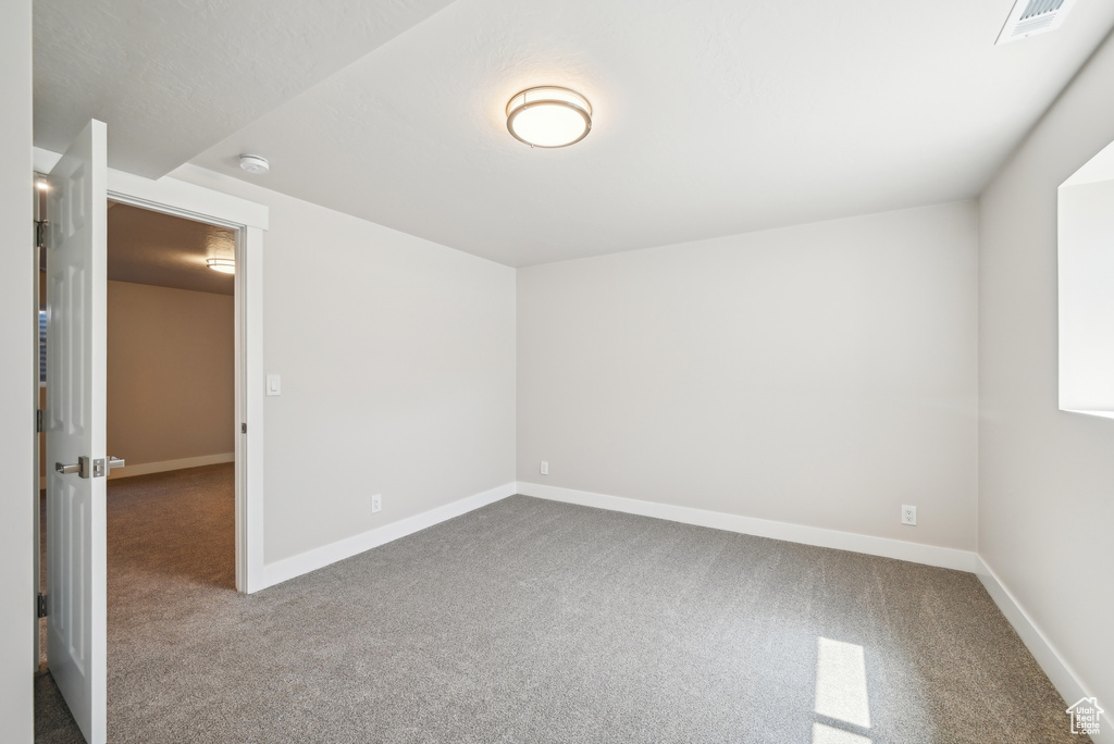 Empty room with visible vents, baseboards, and carpet