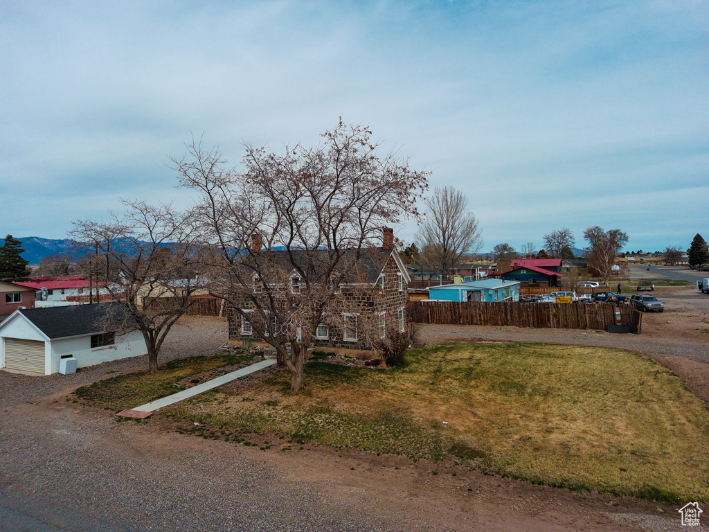 View of front of house with a residential view, a chimney, a mountain view, a garage, and fence