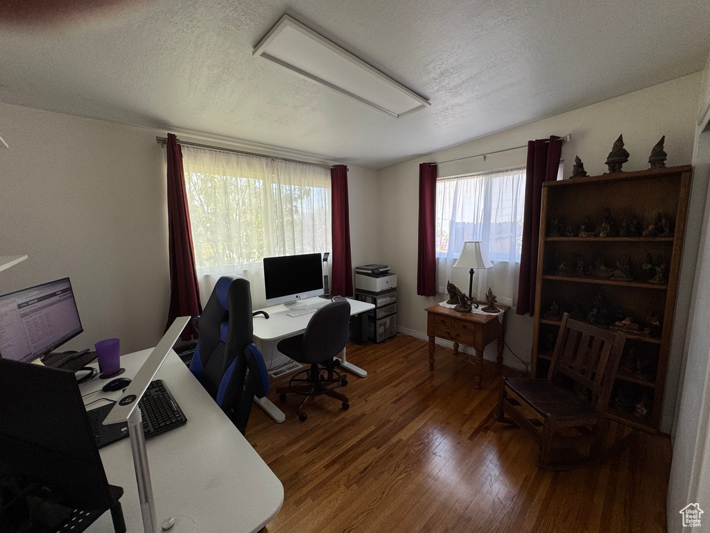 Home office featuring a textured ceiling and wood finished floors