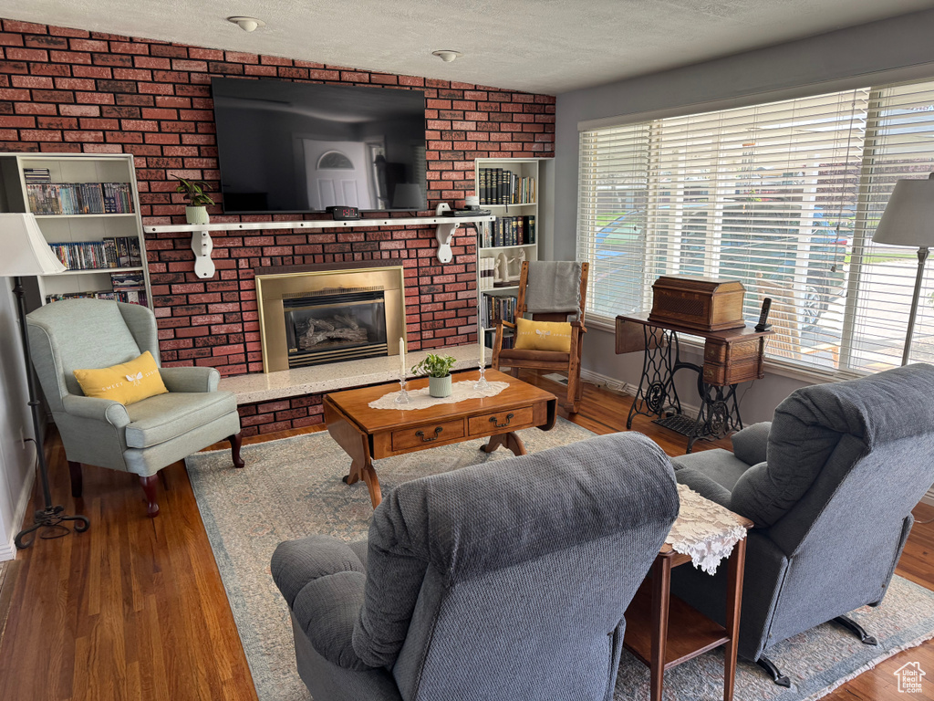 Living area with a textured ceiling, wood finished floors, baseboards, and a wealth of natural light