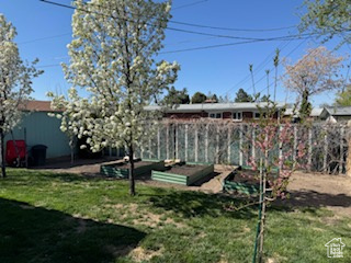 View of yard featuring a vegetable garden and fence