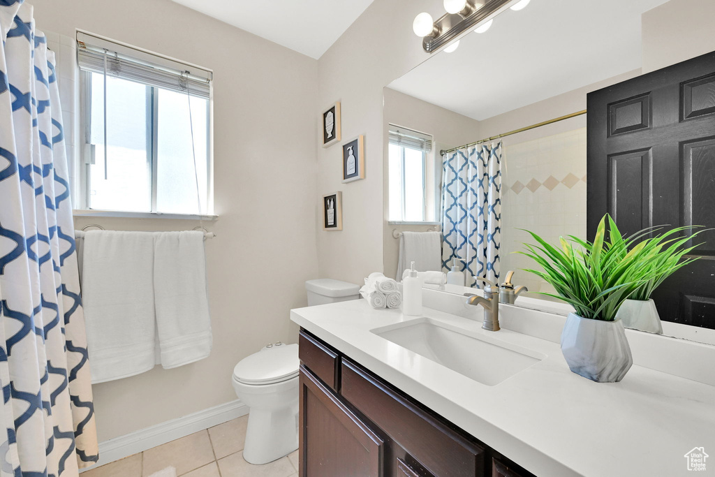 Full bathroom with toilet, vanity, tile patterned flooring, baseboards, and curtained shower