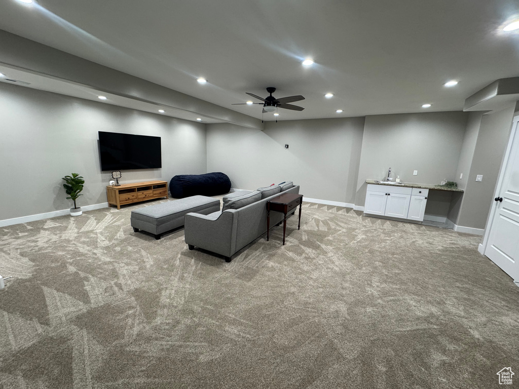 Living area with wet bar, a ceiling fan, light carpet, and recessed lighting