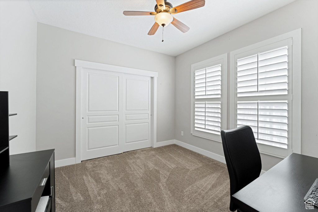 Office with carpet flooring, baseboards, and a ceiling fan