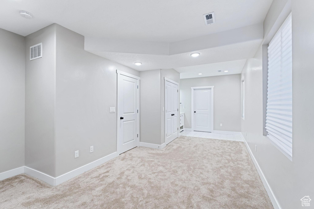 Basement featuring baseboards, carpet, and visible vents
