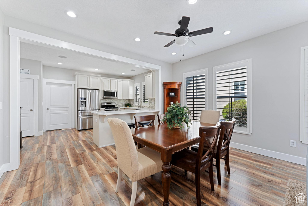 Dining area with light wood-style flooring, ceiling fan, baseboards, and recessed lighting