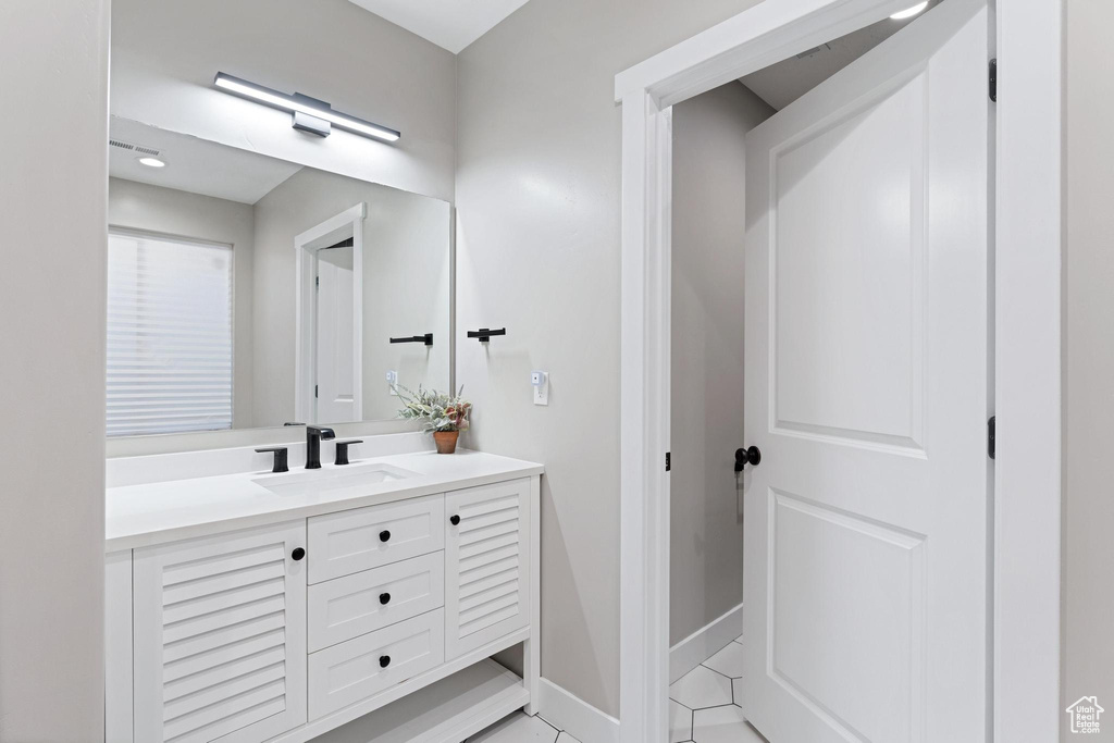 Bathroom with tile patterned floors, vanity, and baseboards