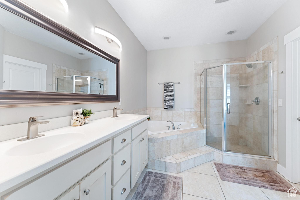 Bathroom featuring a sink, tile patterned floors, a shower stall, and a garden tub