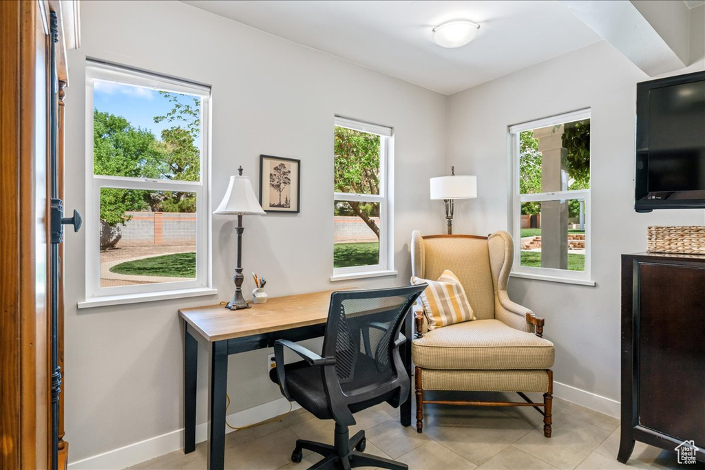 Office space featuring light tile patterned floors, baseboards, and a healthy amount of sunlight
