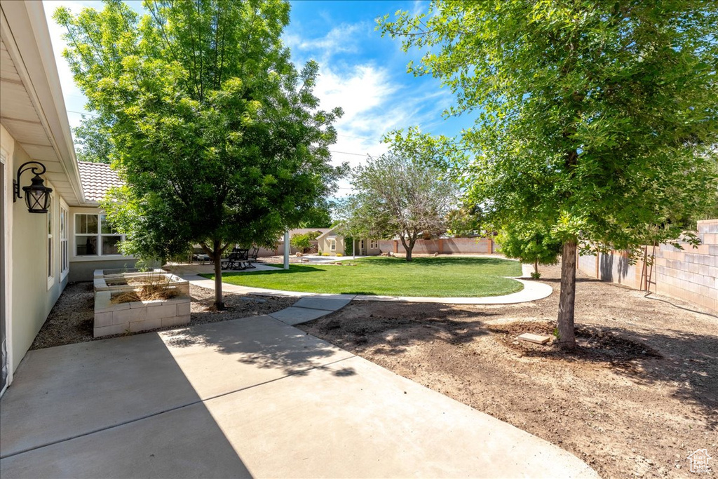 View of yard featuring a patio area, a garden, and fence