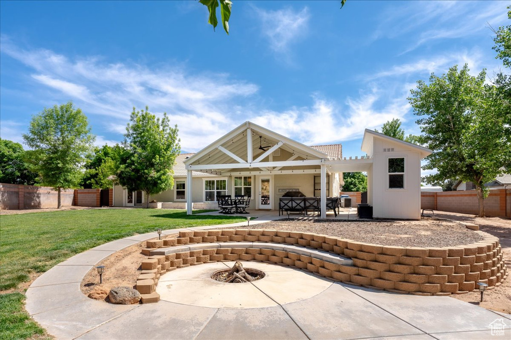 Rear view of house featuring a patio, a yard, a pergola, and fence