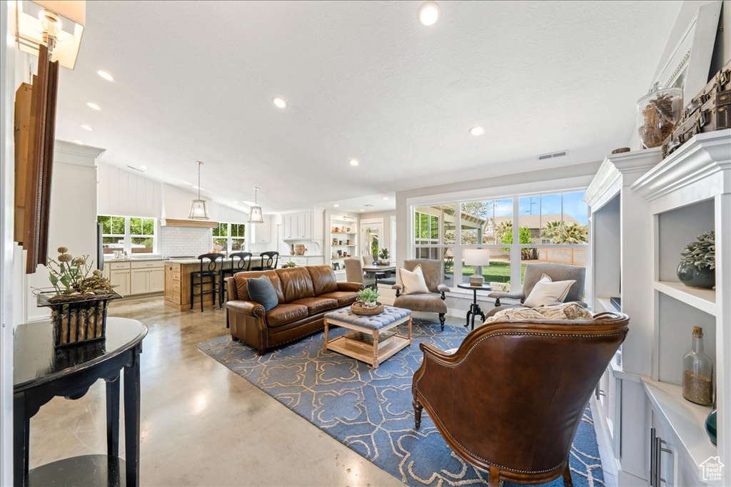 Living area with visible vents, concrete flooring, plenty of natural light, and recessed lighting