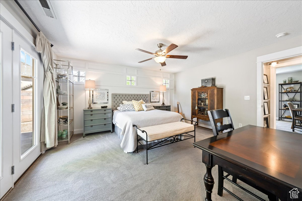 Bedroom featuring visible vents, a ceiling fan, carpet, and a textured ceiling