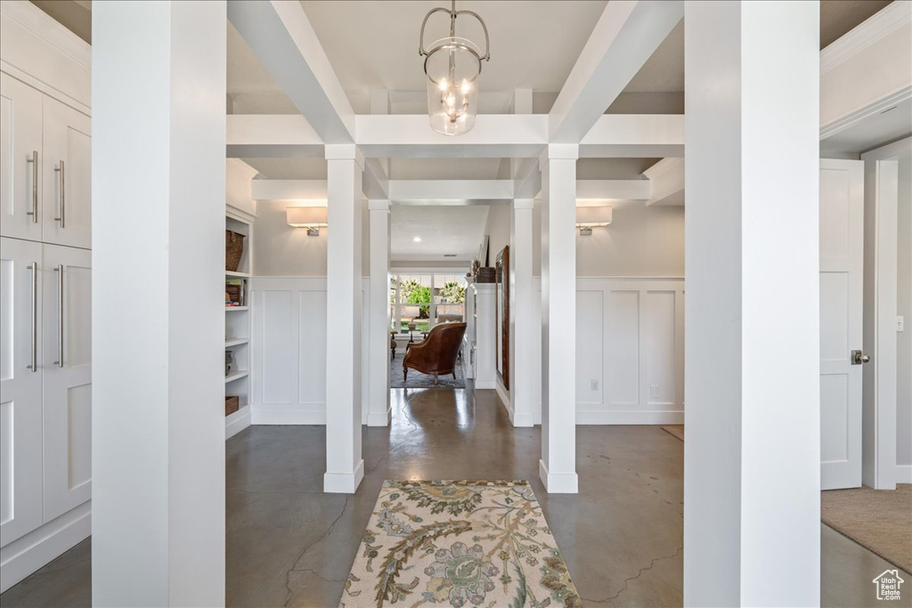 Foyer with concrete floors, wainscoting, and a decorative wall