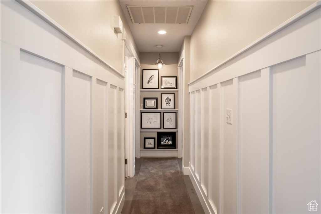 Corridor with recessed lighting, dark colored carpet, visible vents, and baseboards