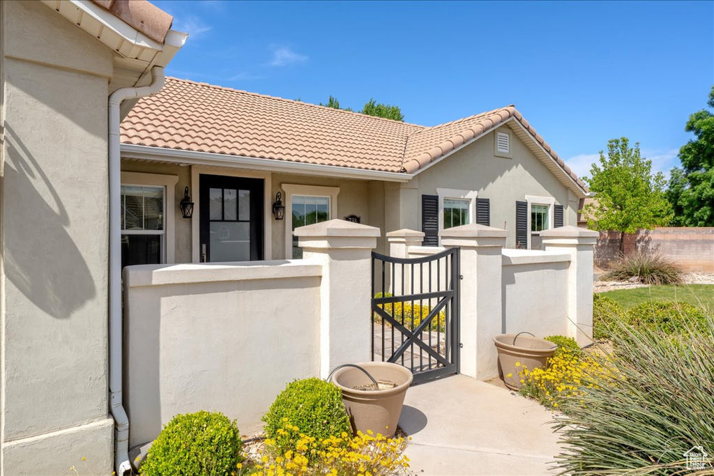 View of front of house featuring a tile roof, stucco siding, a gate, and a fenced front yard