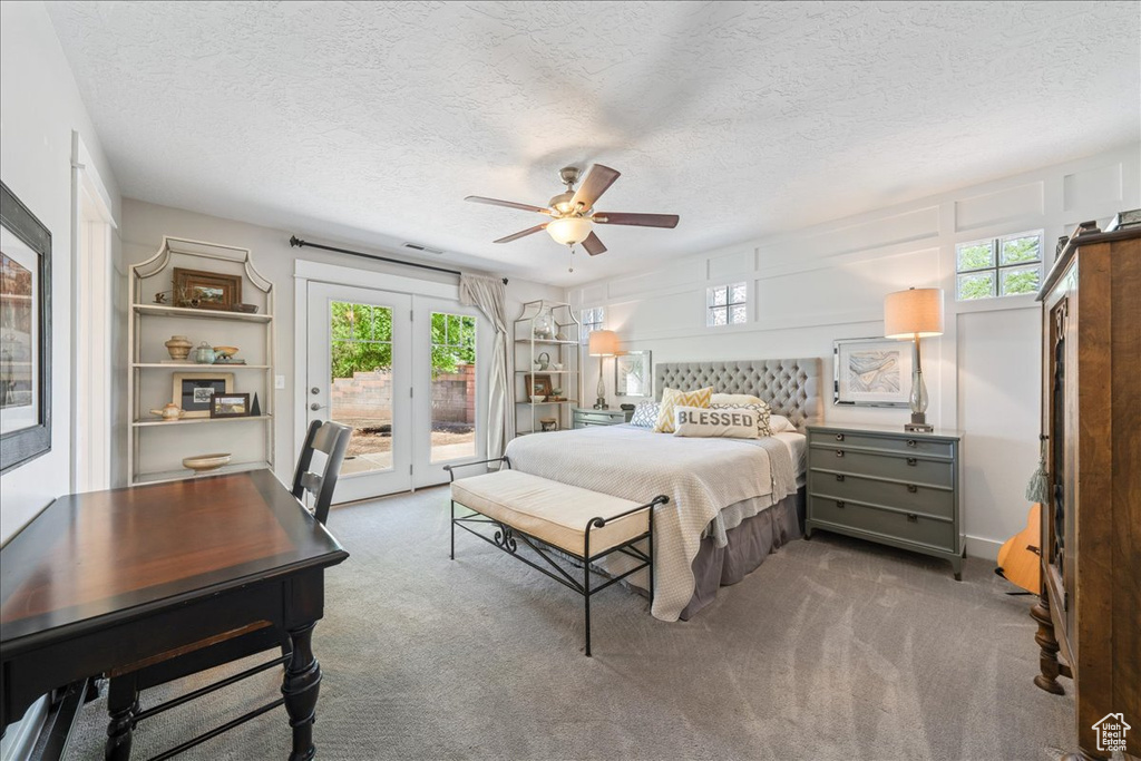 Carpeted bedroom with a ceiling fan, access to outside, and a textured ceiling
