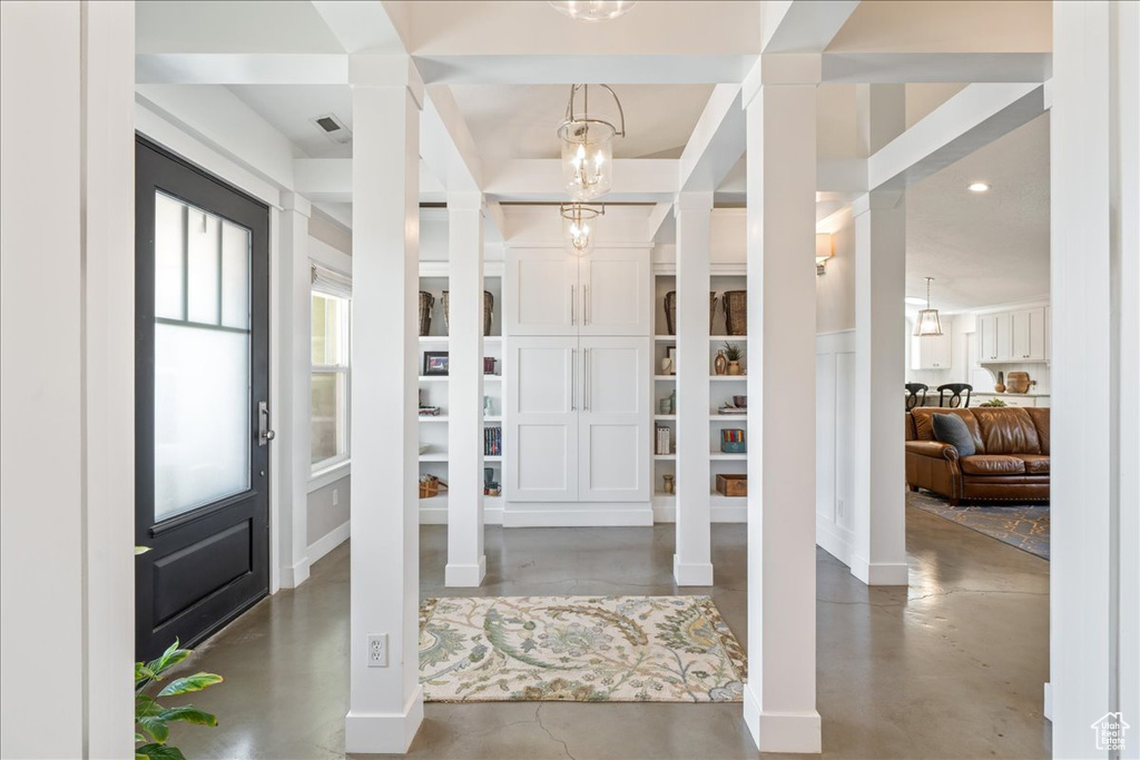 Foyer entrance with visible vents, recessed lighting, finished concrete floors, and decorative columns