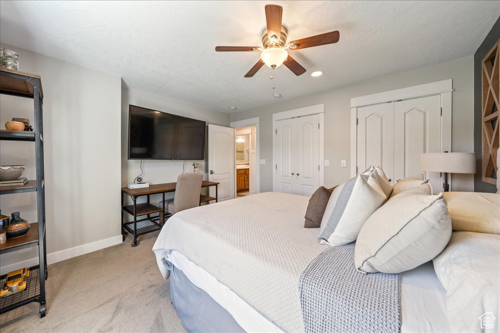 Bedroom with two closets, ceiling fan, light colored carpet, recessed lighting, and baseboards