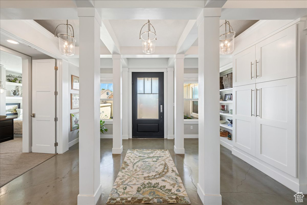 Entrance foyer featuring a chandelier and finished concrete flooring