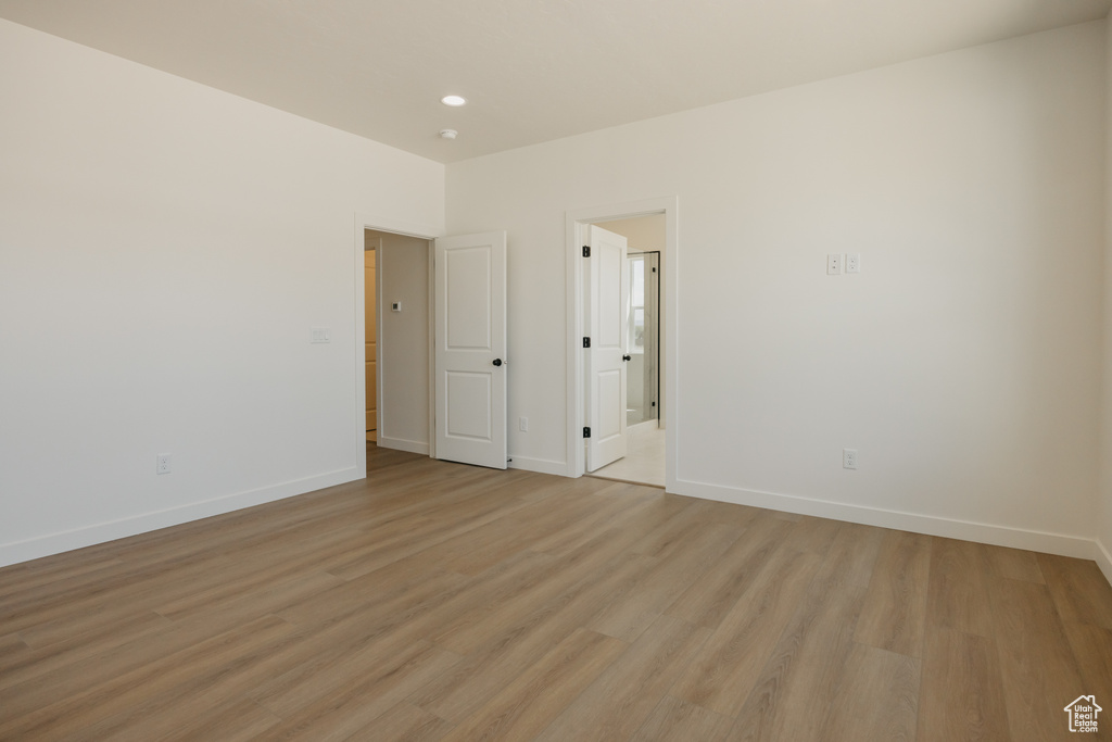 Unfurnished room with light wood-style flooring, baseboards, and recessed lighting