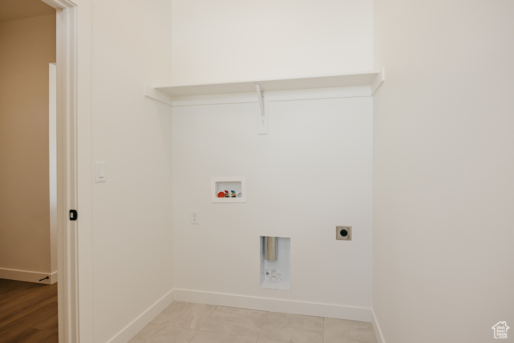 Clothes washing area featuring baseboards, electric dryer hookup, and hookup for a washing machine