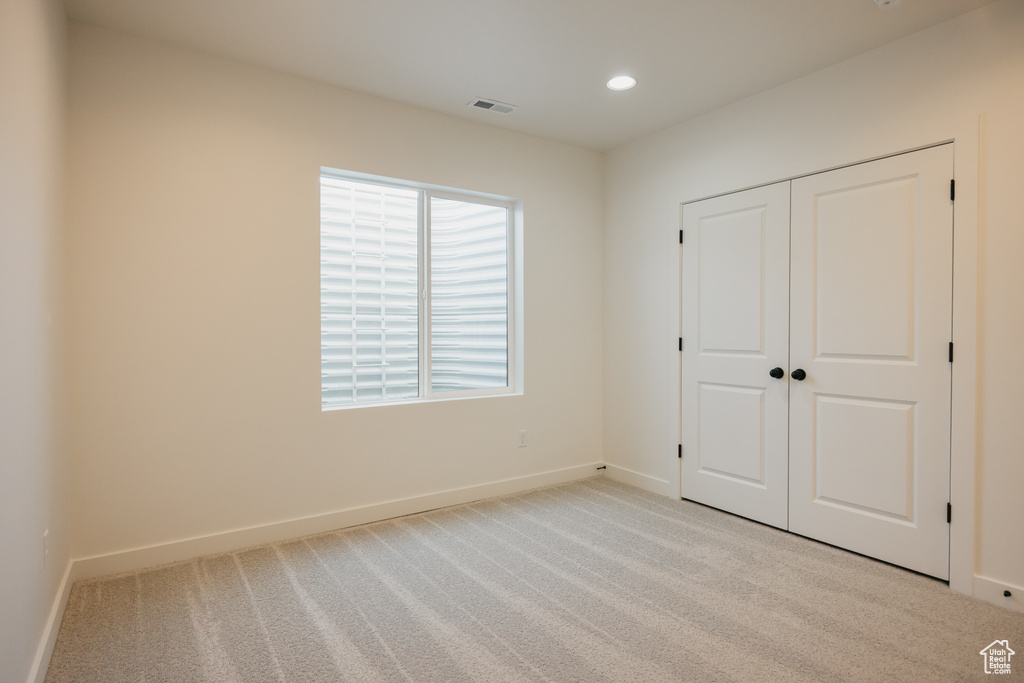 Unfurnished bedroom with baseboards, carpet, a closet, and recessed lighting