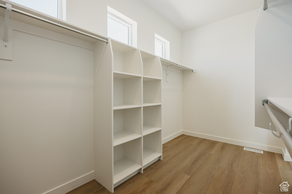 Walk in closet with light wood-type flooring