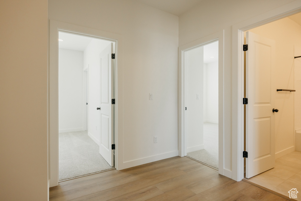 Hallway with light wood-style flooring and baseboards