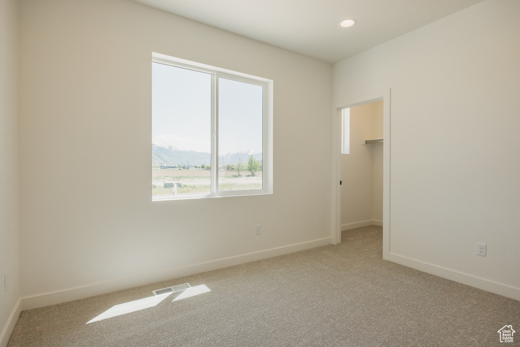 Spare room with light colored carpet, baseboards, and recessed lighting