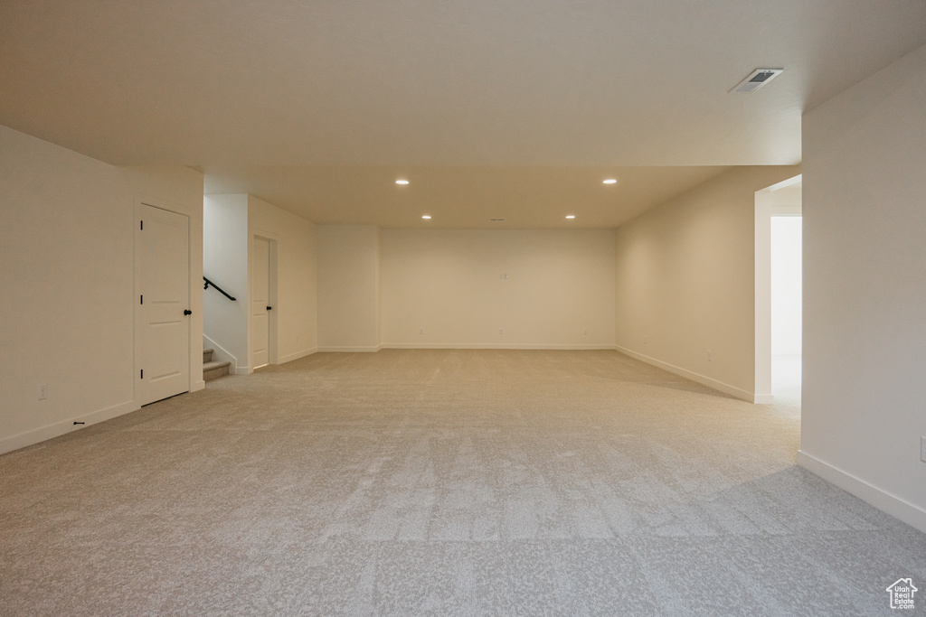 Finished basement featuring recessed lighting, light carpet, stairs, and baseboards