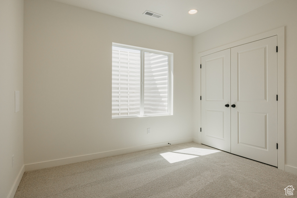 Unfurnished bedroom featuring carpet floors, baseboards, a closet, and recessed lighting