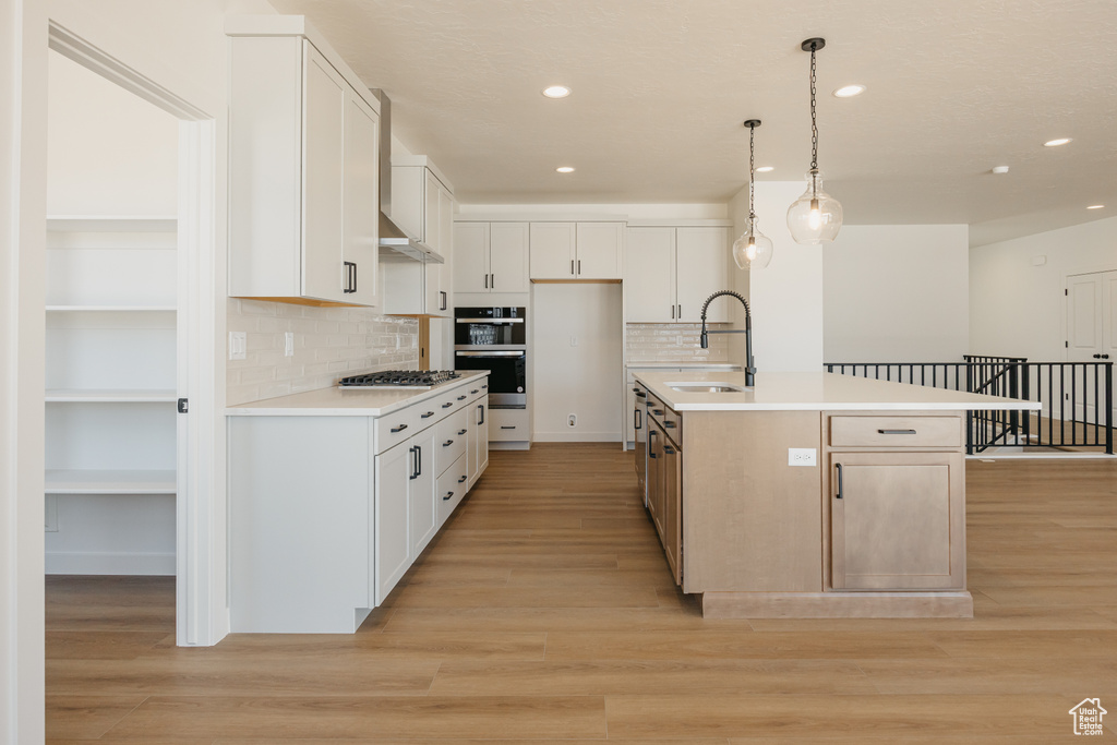 Kitchen featuring a sink, recessed lighting, stainless steel appliances, tasteful backsplash, and light countertops