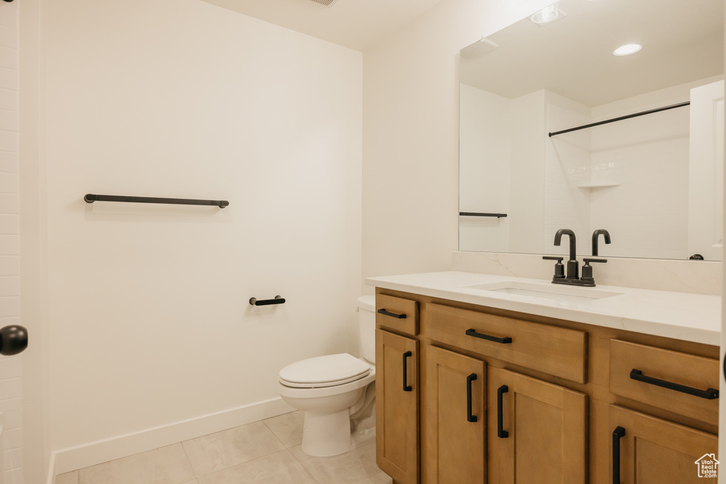 Bathroom featuring toilet, tile patterned flooring, a shower, vanity, and baseboards