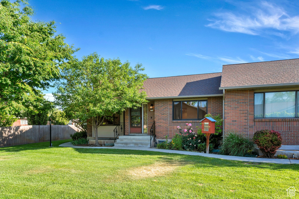 View of front of home with roof with shingles and brick siding