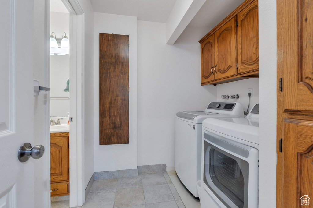 Washroom featuring washer and clothes dryer and cabinet space