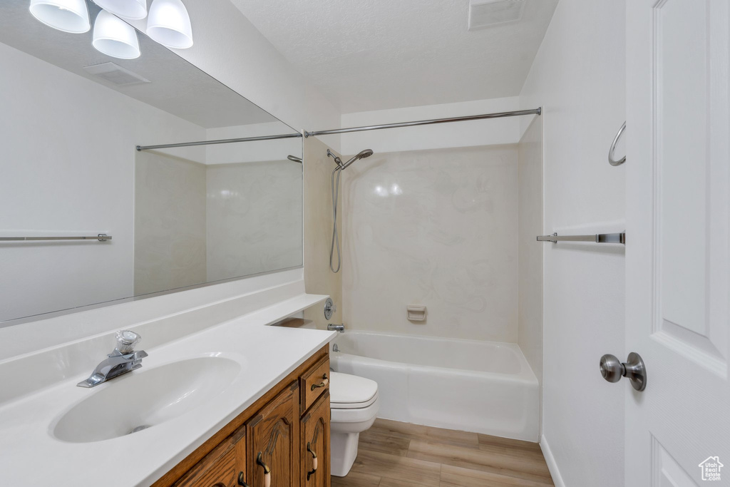 Full bath featuring wood finished floors, vanity, and bathing tub / shower combination