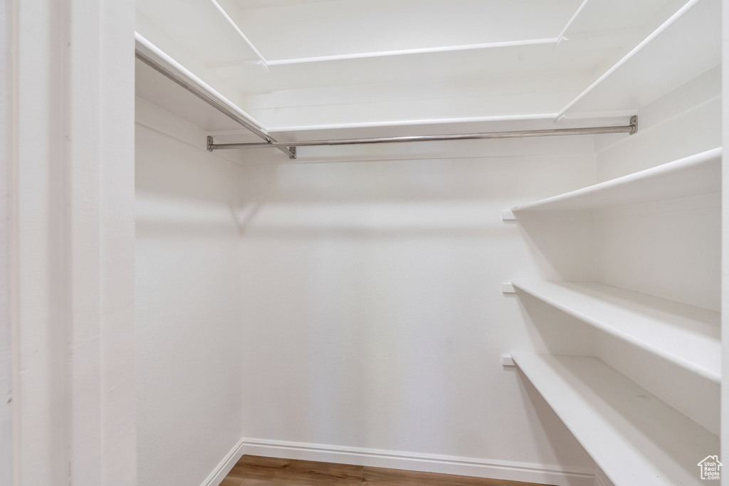 Walk in closet with wood finished floors