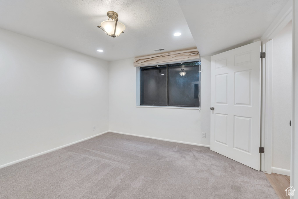 Carpeted empty room featuring recessed lighting